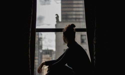 Silhouette of woman looking out a window